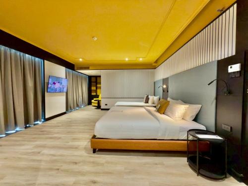 a bedroom with a large bed with a yellow ceiling at The Quarter Saphankhwai by UHG in Bangkok
