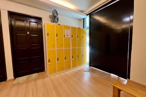 a locker room with yellow lockers and a clock on the wall at 8 mins driving to TC Beach at Holiday Guest House in Kuantan