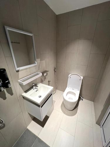 a bathroom with a toilet and a sink and a mirror at 8 mins driving to TC Beach at Holiday Guest House in Kuantan