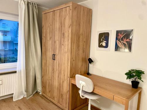 a wooden cabinet in a room with a desk at Westflügel Apartment mit Parkplatz und zentraler Lage in Bad Rothenfelde