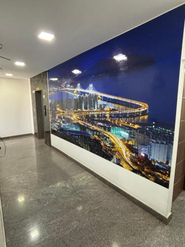 a large wall mural of a city at night at Palm Mystic Inn - Indiranagar in Bengaluru