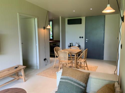 un salon avec une table et des chaises dans l'établissement Lisière du Lac - 100m du Lac, à Parentis-en-Born