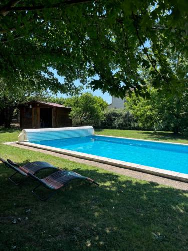 une chaise et une piscine dans une cour dans l'établissement Studio meuble, à Marssac-sur-Tarn