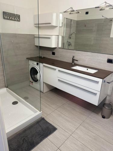 Faggeto Lario にあるCasa di Spinoの洗面台と洗濯機を備えたバスルーム