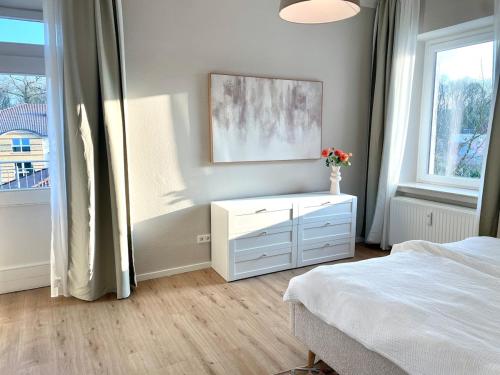 a bedroom with a bed and a dresser and a window at Sonnendeck Suit - zentral und ruhig in Bad Rothenfelde