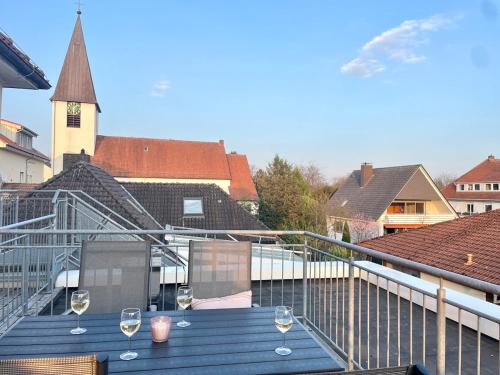 a table with wine glasses on a balcony at Sonnendeck Suit - zentral und ruhig in Bad Rothenfelde