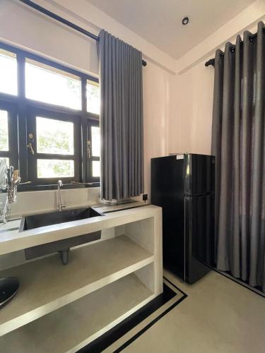 a kitchen with a sink and a refrigerator at Casora - Hiriketiya in Dikwella North