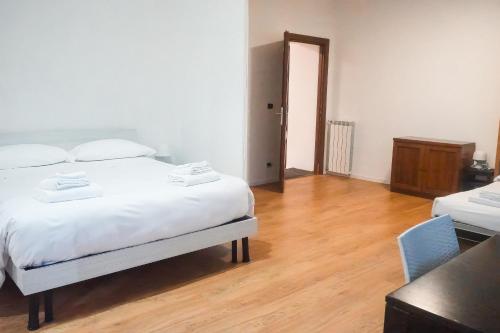a bedroom with a white bed and a wooden floor at La Boheme SMART Hotel in Turin