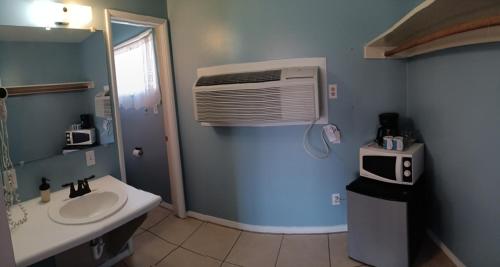 a bathroom with a sink and a air conditioner at El Rancho Motel in Bishop