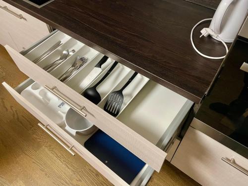 an open drawer in a kitchen with utensils at City apartment Tallinn Free parking in Tallinn