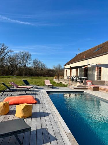 une piscine avec des chaises et une maison dans l'établissement Domaine Solognot avec Bar, Sauna, Jacuzzi, Piscine, à Villemurlin