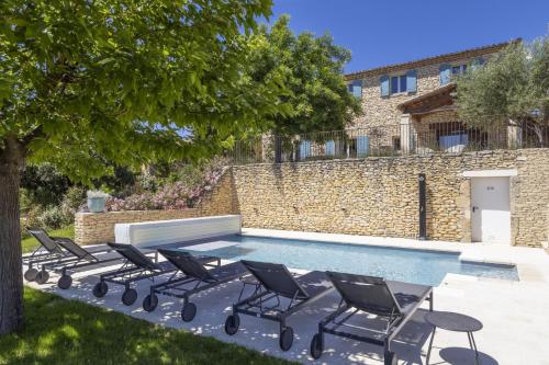 un groupe de chaises assises à côté d'une piscine dans l'établissement Villa Vue Luberon, à Gordes