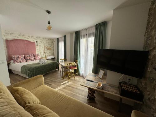 a living room with a couch and a flat screen tv at ATENEO CUENCA Suites con cocina en el casco histórico in Cuenca