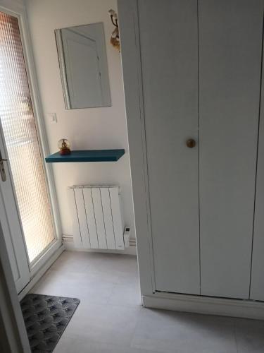 a white room with a door and a mirror at La Cabine du Man, classé 2 étoiles in Roscoff