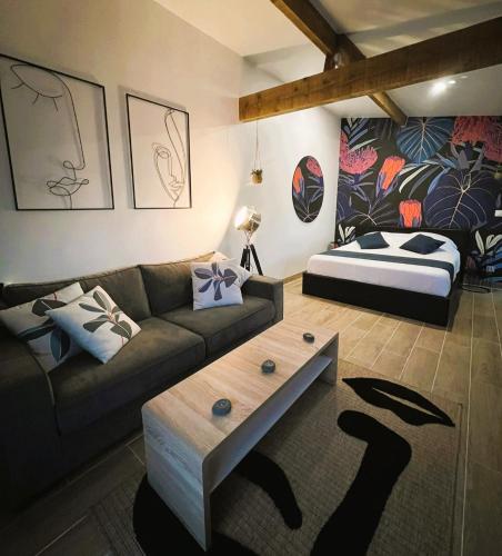 un salon avec un canapé et un lit dans l'établissement L'Echappée, à Saint-Jean-dʼIllac