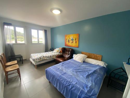 - une chambre avec des murs bleus, un lit et un canapé dans l'établissement Magnifique villa au calme a St Mitres les Remparts, à Saint-Mitre-les-Remparts