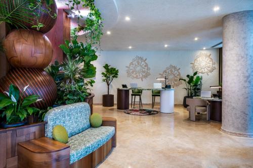 a lobby with plants and a chair and a table at Swissôtel Tbilisi in Tbilisi City