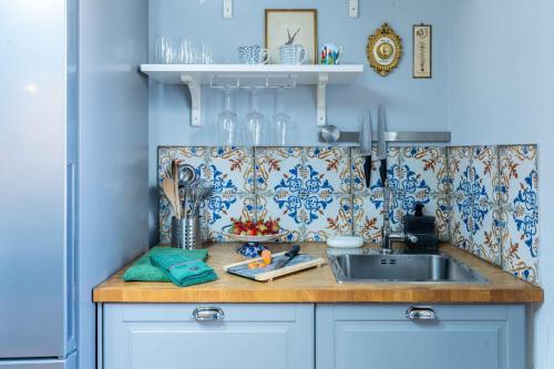 a kitchen with a sink and a counter with blue walls at Luxury Apartment Angelio in Barga