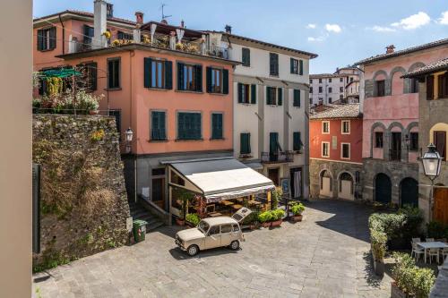 an old car parked in an alley with buildings at Luxury Apartment Angelio in Barga