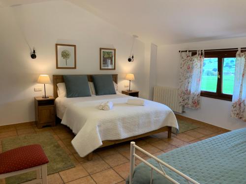 ein Schlafzimmer mit großem Bett und Fenster in der Unterkunft La Cabaña de Meruelo in San Miguel de Meruelo