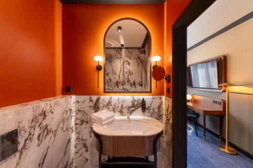 a bathroom with a sink and a mirror at Mercure Gdynia Centrum in Gdynia