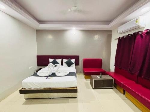 奥兰加巴德Hotel Rajlaxmi Executive的一间卧室配有一张床和一张红色长凳
