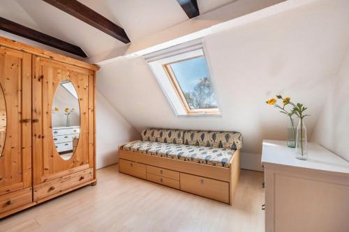 a attic room with a bench and a window at Dat Haddehuus in Wangerland