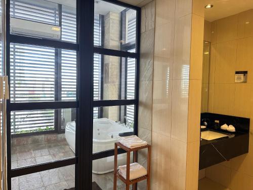 a bathroom with a tub and a large window at Luxent Hotel in Manila