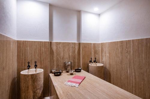 a bathroom with two sinks and a wooden table at Swissôtel Tbilisi in Tbilisi City