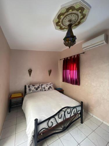 a bedroom with a bed and a chandelier at Riad Nour Resorts-Riad Nour Travel in Marrakech