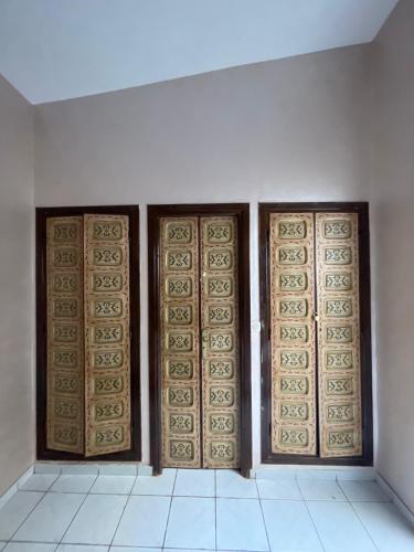 a room with three wooden doors on a white wall at Riad Nour Resorts-Riad Nour Travel in Marrakech