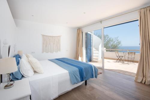 a bedroom with a bed and a view of the ocean at Domus Alba A in Portocolom