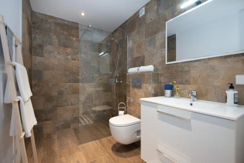 a bathroom with a toilet and a sink and a mirror at Domus Alba A in Portocolom