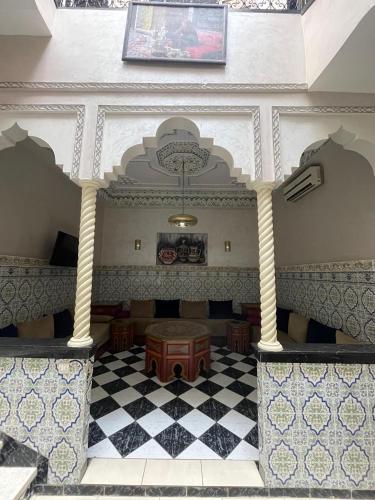 a room with a table and a checkered floor at Riad Nour Resorts-Riad Nour Travel in Marrakech
