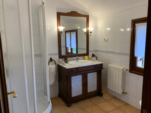 ein Badezimmer mit Waschbecken, Spiegel und Badewanne in der Unterkunft La Cabaña de Meruelo in San Miguel de Meruelo