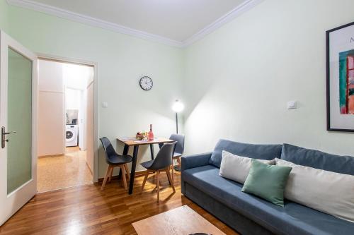 a living room with a blue couch and a table at Aris123 by Smart Cozy Suites - Apartments in the heart of Athens - 5 minutes from metro - Available 24hr in Athens