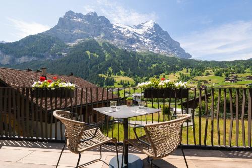 a table and chairs on a balcony with a mountain at Boutique Hotel Glacier in Grindelwald