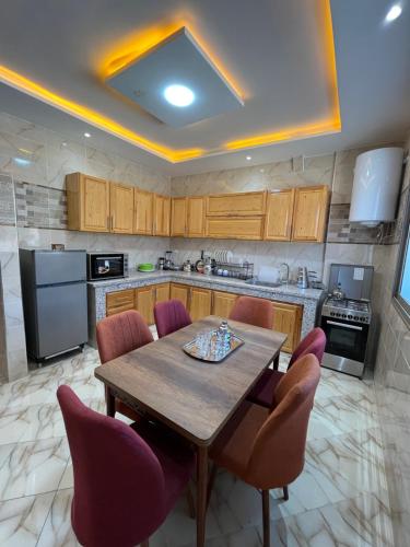 a kitchen with a wooden table and purple chairs at chems surf House in Tamraght Ouzdar