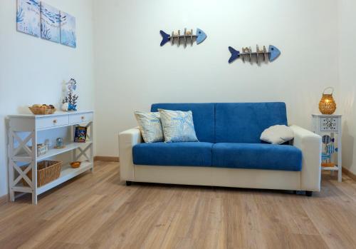 a blue couch sitting in a living room at Sardinianworld - Josto Panoramic House in S'archittu Cuglieri