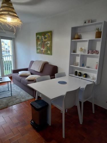 un salon avec une table blanche et un canapé dans l'établissement T2 standing Gruissan, à Gruissan