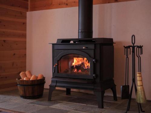 a stove in a room with a fireplace at Izumigo AMBIENT Azumino Cottage in Azumino
