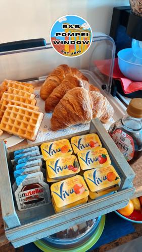 un plateau de fromage, de pain et d'autres aliments dans l'établissement B&b Pompei Window, à Pompéi