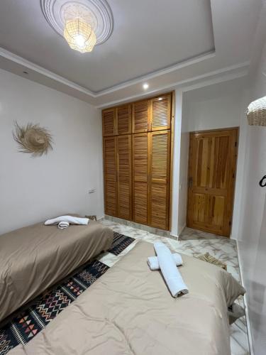 a bedroom with two beds and a chandelier at chems surf House in Tamraght Ouzdar