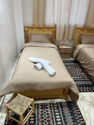 a bedroom with two beds with a towel on the bed at chems surf House in Tamraght Ouzdar