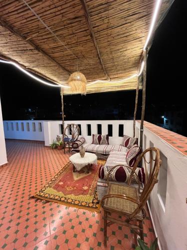 a living room with chairs and a couch on a roof at chems surf House in Tamraght Ouzdar