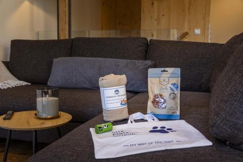 a table with a bag and a box on a couch at Vitalhof am Kreischberg by ALPS RESORTS in Bodendorf