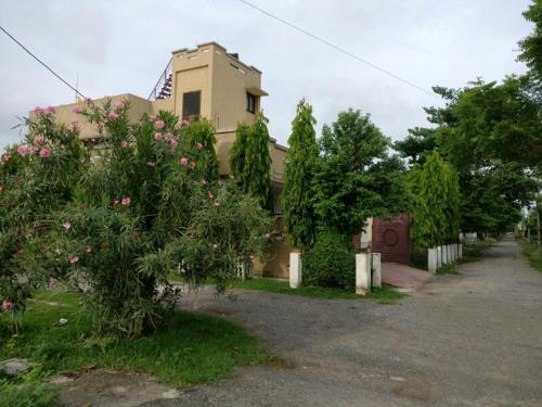 a house with a tree in front of it at Cheerful 2BHK green Villa by Suvana Organics in Lucknow