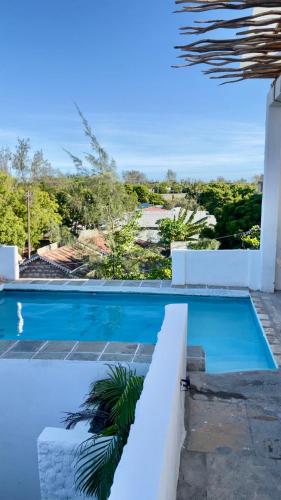 a blue swimming pool with a view of the ocean at Madenge house casa zucchero in Watamu