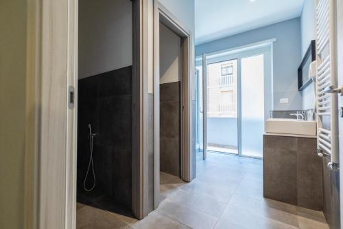 a hallway with a door to a bathroom with a sink at Hostel Trastevere in Rome