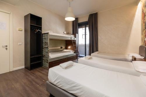 a room with two beds and a couple of bunk beds at Hostel Trastevere in Rome